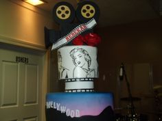 a three tiered cake decorated with an image of marilyn monroe and two movie reels