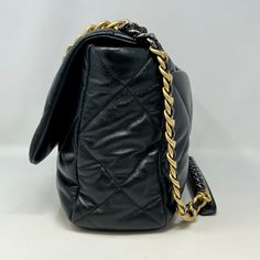 Chanel Maxi 19 Flap Bag with Bi-colored Chain Link Shoulder Strap, Interlocking CC Logo and Quilted Pattern (includes Dustbag) Designer = Chanel Color = Black Material = Lamb Skin Condition = Excellent Height = 10 Width = 14 Depth = 4.5" Class = Premier Location: Wilmette Item Number: 20201-73 Item ID: 300893 Category: Shoulder Bag Travel Bag With Chain Strap And Double Flap, Travel Bag With Double Flap And Chain Strap, Black Double Flap Bag For Office, Black Double Flap Office Bag, Black Double Flap Shoulder Bag, Black Flap Bag With Gold-tone Hardware, Luxury Chain Crossbody Bag, Designer Black Bag With Chain, Designer Black Flap Bag With Chain Strap