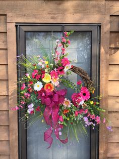 a wreath with flowers on the front door