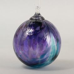 a purple and blue glass ornament on a white background