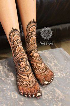 the legs and feet of a woman with henna tattoos