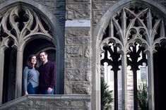 a man and woman standing on the balcony of an old building