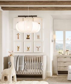 a baby's room with white furniture and pictures on the wall, including a crib