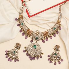 Description: Indulge in the vintage elegance of the Yasmin hasli necklace set. Inspired by India's rich jewelry heritage, it features opulent Moissanite stones, nakshi motifs, and a central peacock motif surrounded with bird and floral patterns. Crafted in 925 silvers with Victorian plating, sapphire beads, and cluster pearl drops, it exudes vintage charm. Product Information: Metal: 925 Silver with Victorian Plating Length: Necklace- 18cm, Earrings- 7cm Stones: High Grade CZ Stones Findings: Ho Kundan Necklaces With Intricate Design For Reception, Ornate Kundan Necklace For Reception, Traditional Jewelry Sets With Intricate Design For Reception, Intricate Design Jewelry Sets For Reception And Festivals, Dual-tone Kundan Chandbali Necklace For Wedding, Temple Necklace With Intricate Chandbali Design For Reception, Ornate Chandbali Jewelry With Stone Work, Chandbali Necklaces With Intricate Design For Reception, Ornate Chandbali Jewelry For Reception