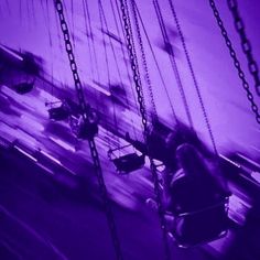 a purple photo of people on a swing