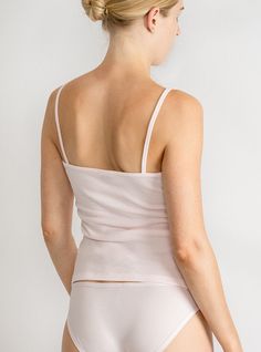 Lightweight layer in breathable organic cotton A wardrobe essential that’s perfect on its own or layered with a sweater. The camisole’s sweetly scooped neckline and slender spaghetti straps flatter décolletage and add understated elegance to the everyday. Made in North Carolina using 100% USA-grown organic cotton— the best and softest around. Wear your Lake Jane bralette under for a cool layered look! Because of the high quality of this organic fabric, you’ll get tons of wear out of your cami wi Chic Stretch Camisole With Delicate Straps, Delicate Straps Tank Camisole For Layering, Feminine Tops With Spaghetti Straps And Built-in Bra, Feminine Camisole Tank Top For Loungewear, Layering Tank Camisole With Delicate Straps, Feminine Spaghetti Strap Tank Top For Loungewear, Feminine Fitted Camisole With Adjustable Straps, Feminine Tank Top With Adjustable Straps, Fitted Feminine Camisole With Adjustable Straps