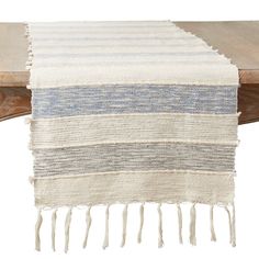 a white and blue striped table runner on top of a wooden table with two chairs