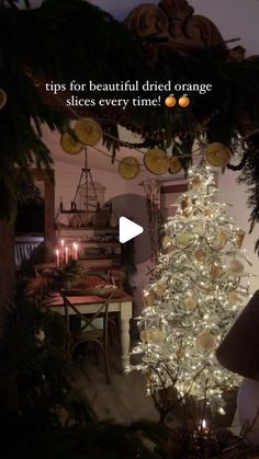 a decorated christmas tree in a living room next to a table with candles on it