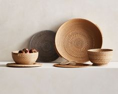 three woven bowls and two plates on top of each other, one with nuts in it