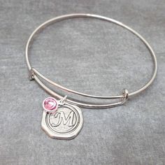 High-quality stainless steel bangle with initial pendant and Swarovski crystal birthstone of your choice!  Thick wire silver bangle is adjustable for any wrist size and super comfortable.  A classic look for everyday wear. This is an AMAZING deal!! Wonderful gift for birthdays, Valentine's, bridesmaids, new mothers, etc. Each bracelet comes with a free gift box.  Initial charms are in the style of antique wax seals used to close envelopes or love letters.   The wax seal pendant is silver plated Personalized Monogram Adjustable Jewelry, Personalized Adjustable Monogram Jewelry, Personalized Monogram Adjustable Jewelry Gift, Adjustable Monogram Jewelry For Personalized Gift, Adjustable Monogram Round Bracelets, Adjustable Initials Pendant Jewelry, Adjustable Initial Pendant Jewelry, Adjustable Sterling Silver Monogram Jewelry, Adjustable Monogram Sterling Silver Jewelry