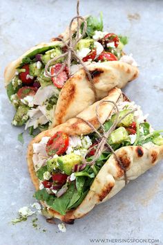 two pita breads filled with vegetables and feta cheese on top of each other