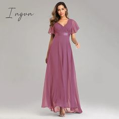 a woman wearing a long purple dress with flutter sleeves and a v - neckline