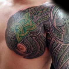 a close up of a man's chest with tattoos on it