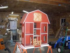 a red barn is being built in a garage