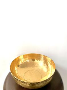 a golden bowl sitting on top of a wooden table