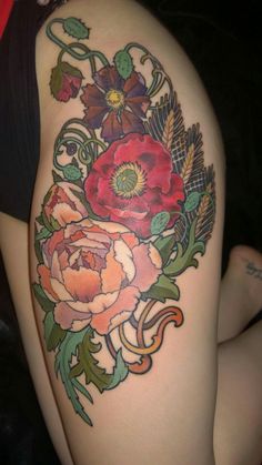 a woman's thigh with flowers and leaves on it