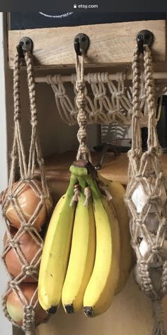 some bananas hanging from ropes on a wall