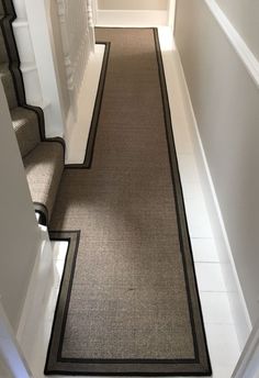 an empty hallway with carpeted stairs and white walls