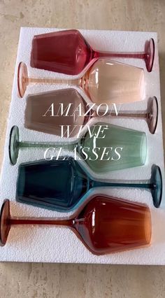 four different colored vases sitting on top of a white towel with the words amazon wake of kisses