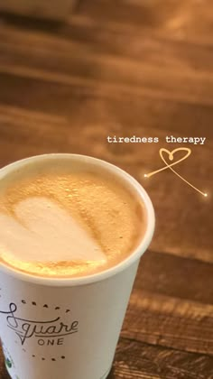 a close up of a cup of coffee on a table with the words trueness therapy above it