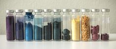 there are seven bottles with different colored sand in them