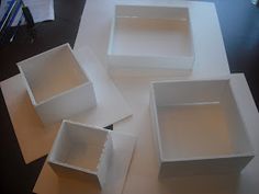 four empty white boxes sitting on top of a table