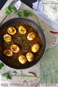 an egg vindaloo and stir fry in a skillet with herbs on the side