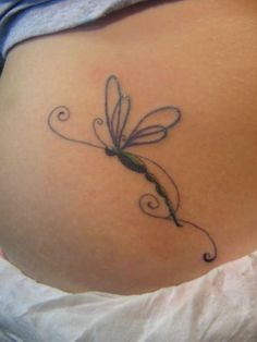 a woman's stomach with a dragonfly tattoo on it