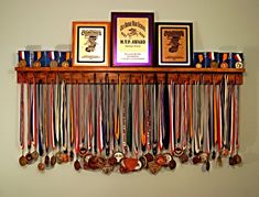 a wall mounted rack with medals and framed pictures