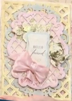 a close up of a greeting card with a pink bow on the front and an ornate border around it