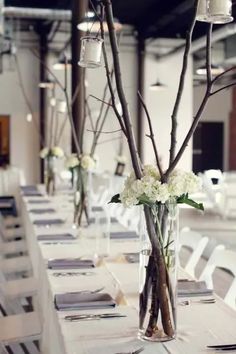 there is a vase with flowers and candles on the table in front of chairs that are lined up