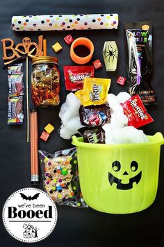 the contents of a halloween treat bag laid out on a black surface with candy and candies