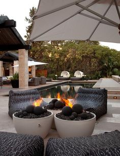 an outdoor fire pit in the middle of a patio