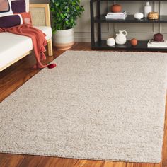 a living room with hardwood floors and a white rug