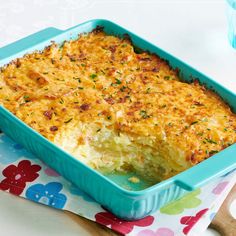 a casserole dish with cheese and herbs in it sitting on a colorful napkin