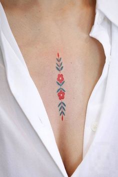 a woman's chest with red flowers and leaves painted on the side by an artist