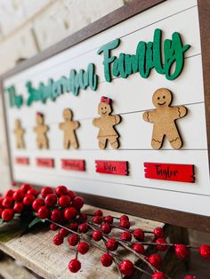 the family sign is decorated with gingerbreads and holly berries on a wooden board