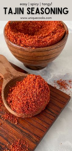 two wooden spoons filled with red seasoning on top of a cutting board