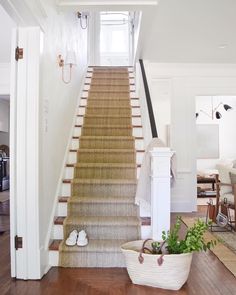 the stairs in this house have been painted white and are lined with beige rugs