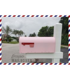 a pink mailbox sitting on top of a white post