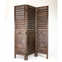 an antique wooden room divider with shutters