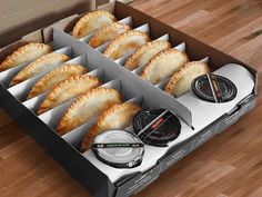 an open box filled with pastries on top of a wooden floor