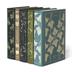 three books with leaves on them sitting next to each other