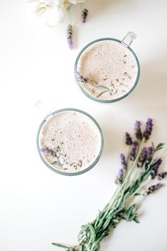 two mugs filled with coffee and lavender sprigs