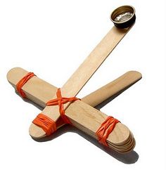 three wooden sticks tied together with orange string and a roll of tape on the end