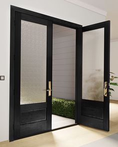 an open door leading into a room with grass growing on the floor and potted plants