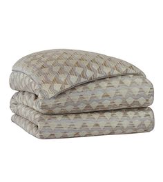 two pillows stacked on top of each other in front of a white background with an abstract pattern