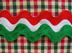 a red, white and green ribbon on a plaid cloth