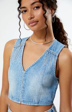 Fall into a denim daze this season with the PacSun Light Indigo V-Neck Denim Vest. This effortlessly cool vest brings a touch of edge to your style, featuring a V-neck design and rhinestone details that add a touch of sparkle to your casual wardrobe.


	Light indigo wash
	Rigid fabric
	V-neckline
	Rhinestone details
	Hook-and-eye front closure
	Sleeveless
	Cropped length
	Fitted
	100% cotton
	Machine washable
	Model is wearing a size xsmall
	Model measurements: 5’6” height, 30” bust, 25.5” waist, 36.5” hip Trendy V-neck Denim Top For Summer, Denim Blue V-neck Denim Vest, Blue Denim V-neck Vest, Denim Blue V-neck Vest For Spring, Trendy Summer V-neck Denim Top, Trendy V-neck Denim Dress, Summer V-neck Denim Top, V-neck Medium Wash Denim Top, Summer Blue Denim Vest With V-neck