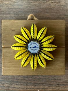 a yellow flower sitting on top of a wooden board